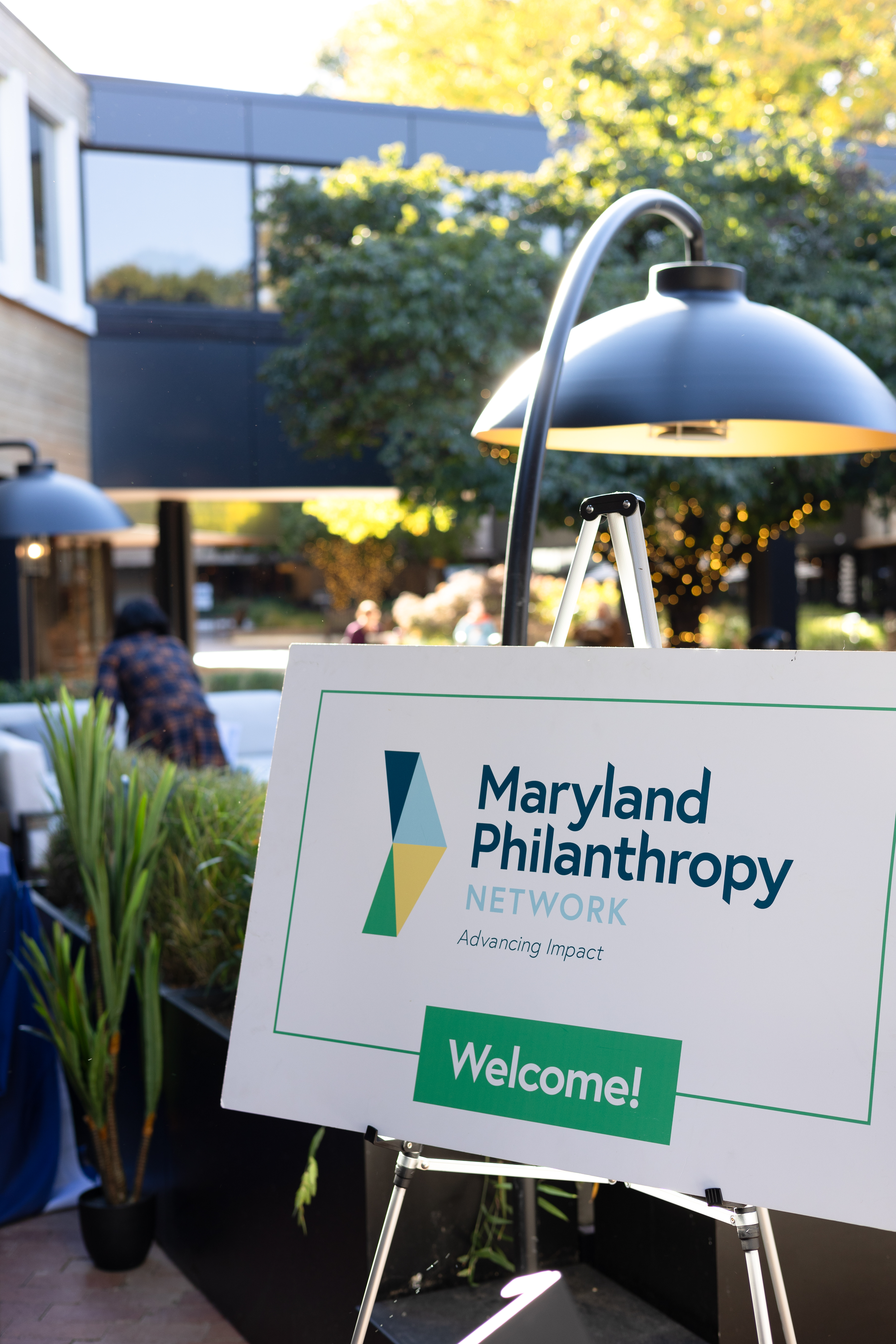 A white sign with MPN's logo reads, "Welcome!" at an event.