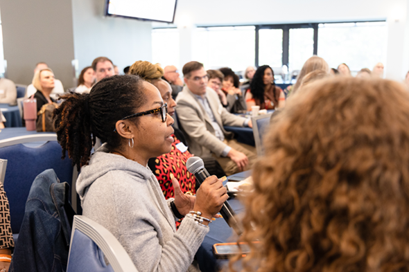 An attendee speaks to the room on a handheld microphone at the 2026 Aging Summit.