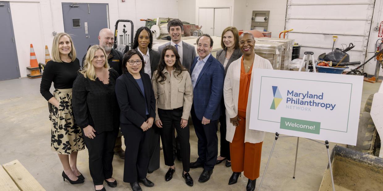 Partners pose for a photo with an MPN logo sign at the JPMC Grant Launch Event in March 2025.