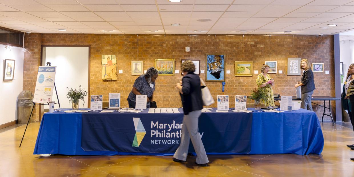 Someone walks up to the registration table at the 2025 Annual Gathering.