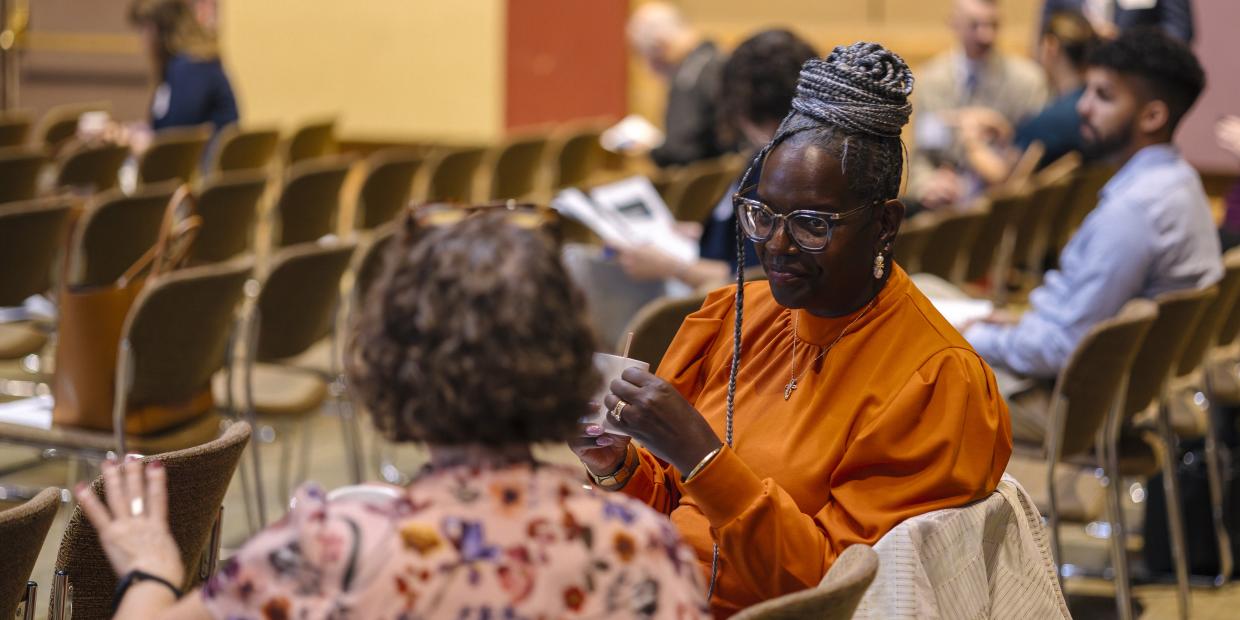 Two people are seated talking to one another during the 2025 Annual Gathering.
