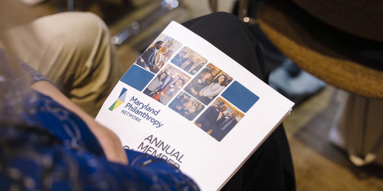 A print program sits in a person's lap during the 2025 Annual Gathering.