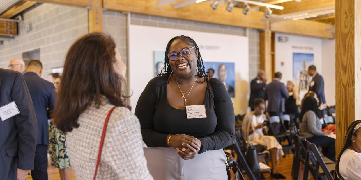 Two people talk and smile at one another at the 2024 Annual Gathering.