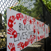 Artwork and protest signs adorn temporary fencing around the White House on June 9. (Katherine Frey/The Washington Post)