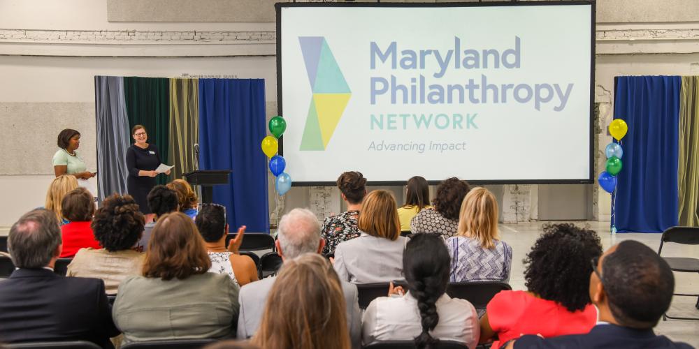 Screen displaying Maryland Philanthropy Network with balloons and people looking on