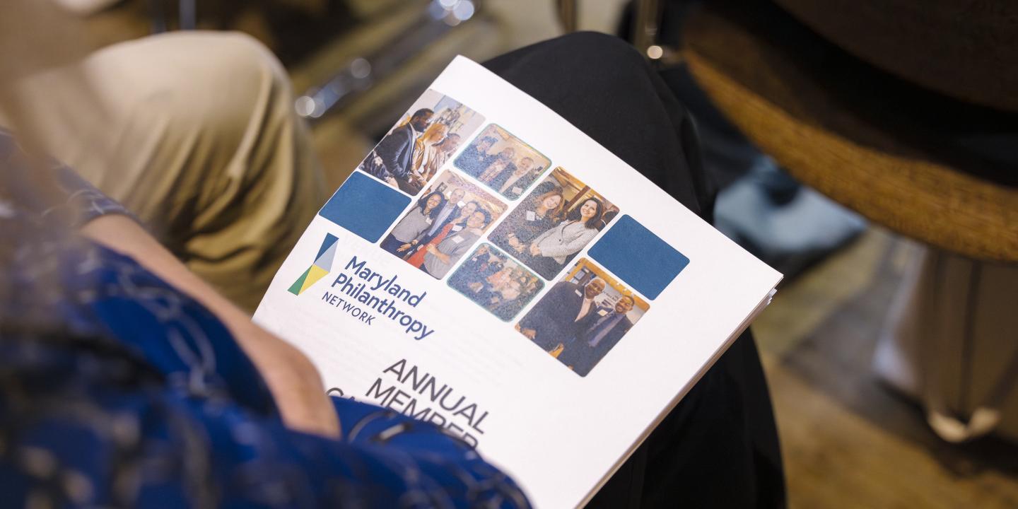 A print program sits in a person's lap during the 2025 Annual Gathering.